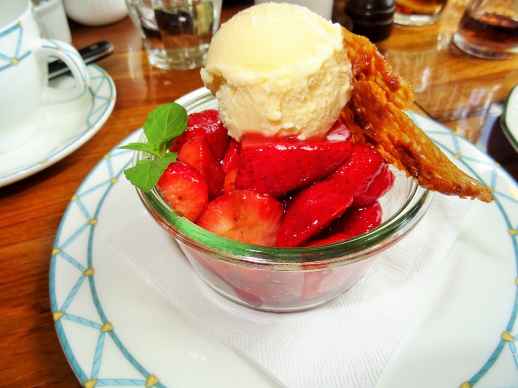 Nydelig dessert med iskrem, hjemmelaget knekk og jordbær dekket av likør.